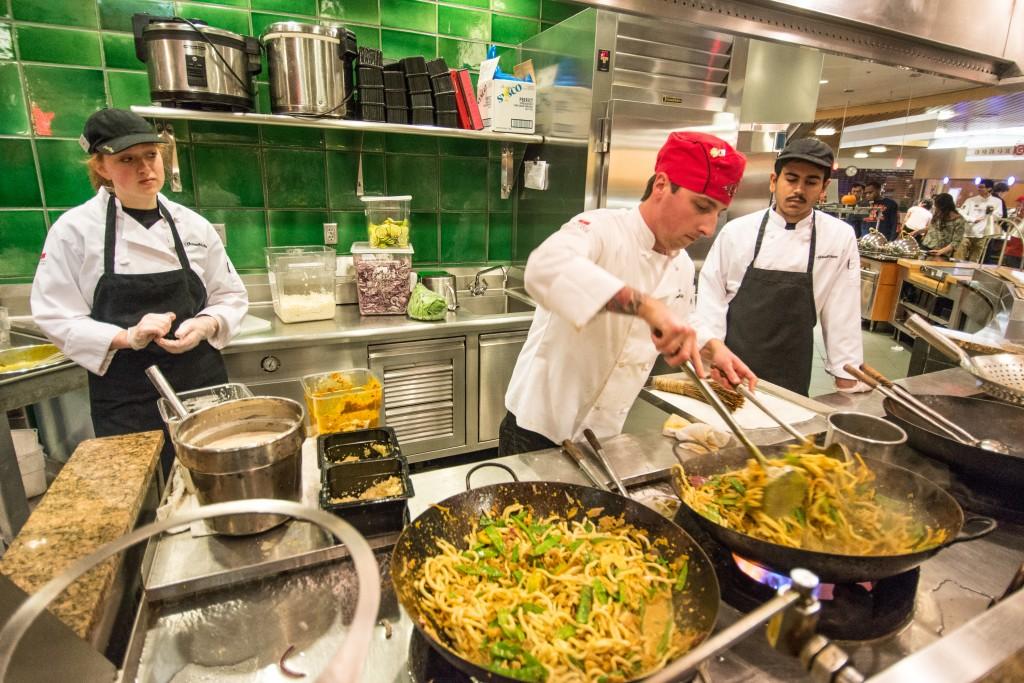 Students and Dining Hall staff help prepare the main dish for the Stir Fry station. John Brady.