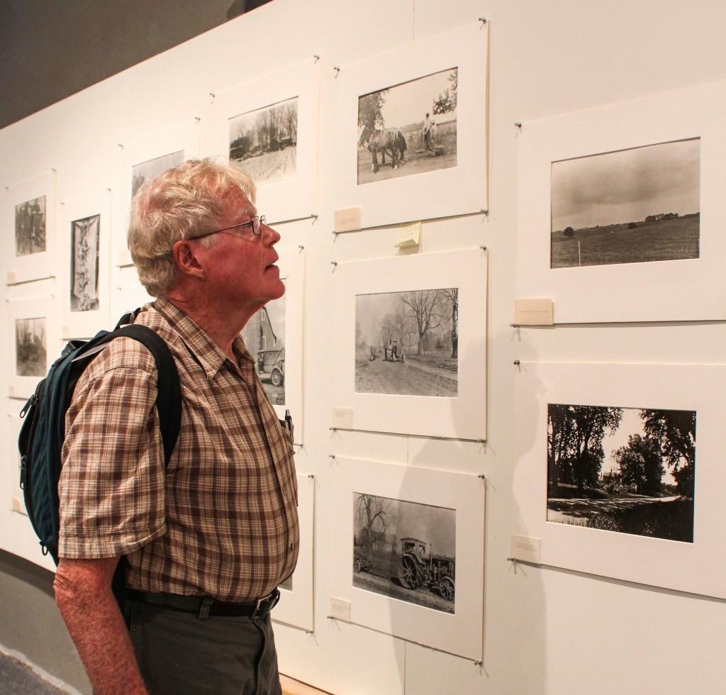 A+visitor+of+Stewart+Gallery+examines+the+photos+taken+by+Egbert+Dunham.+