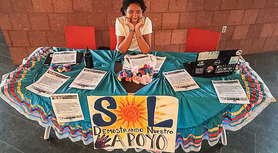 Glorianne Dorce ‘17 publicizes in front of the Dining Hall for events held during National Hispanic Heritage Month. (Photo contributed)