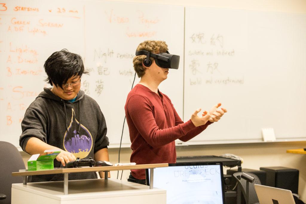 Co-founder+and+co-leader+of+Grinnell+College+Virtual+Reality+Club+Richard+Li+17+assists+a+student+trying+out+the+new+virtual+reality+technology.+Photo+by+Garrett+Wang.+