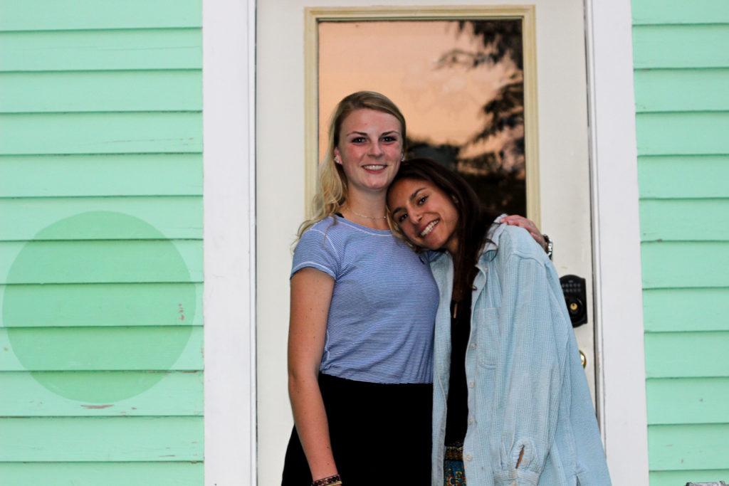 Emma Luhmann 18 and Emma Zimmerman 18 smile outside their colorful house. Luhmann and Zimmerman are looking to lead the Grinnell womens cross country team to new personal and team heights this fall. Photo by Jackson Schulte.