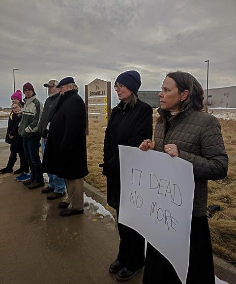 The Reverend Wendy Abrahamson, along with others, protest at Brownells to raise awareness for gun control measures. Photo by Kelly Page.