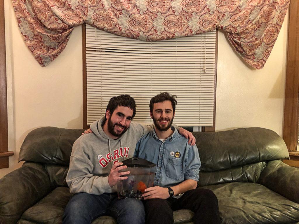Noah Segal and Jacob Friedman, both 19, present their beloved betta fish Norm while wearing I Heart Norm pins at their apartment. Photo by Ingrid Meulemans. 