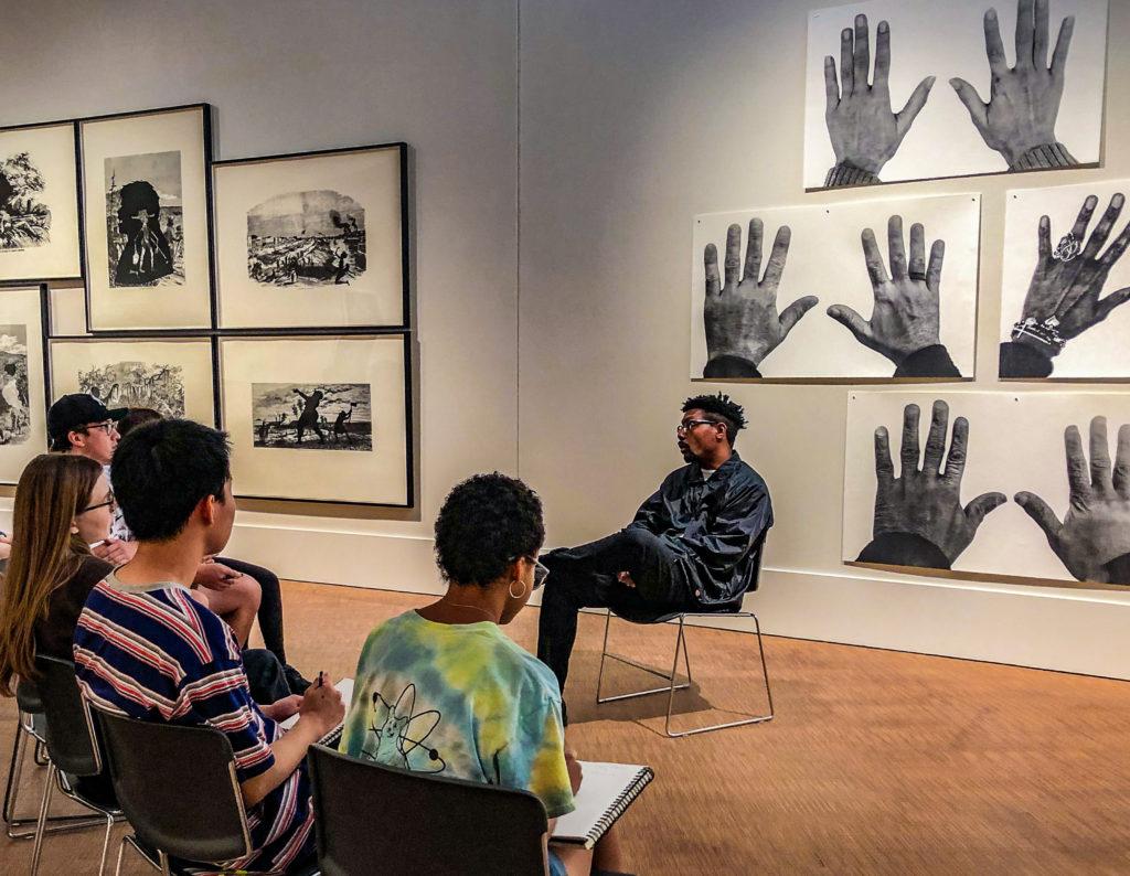 Damon Davis speaks with students at the Grinnell College Museum of Art. Contributed by Tilly Woodward.