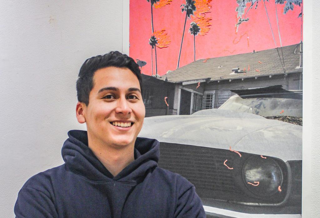 Giani Chavez 20 stands in front of one of his pieces on display at the Smith Gallery. His work explores nostalgia and memory. Photo by Ariel Richards.