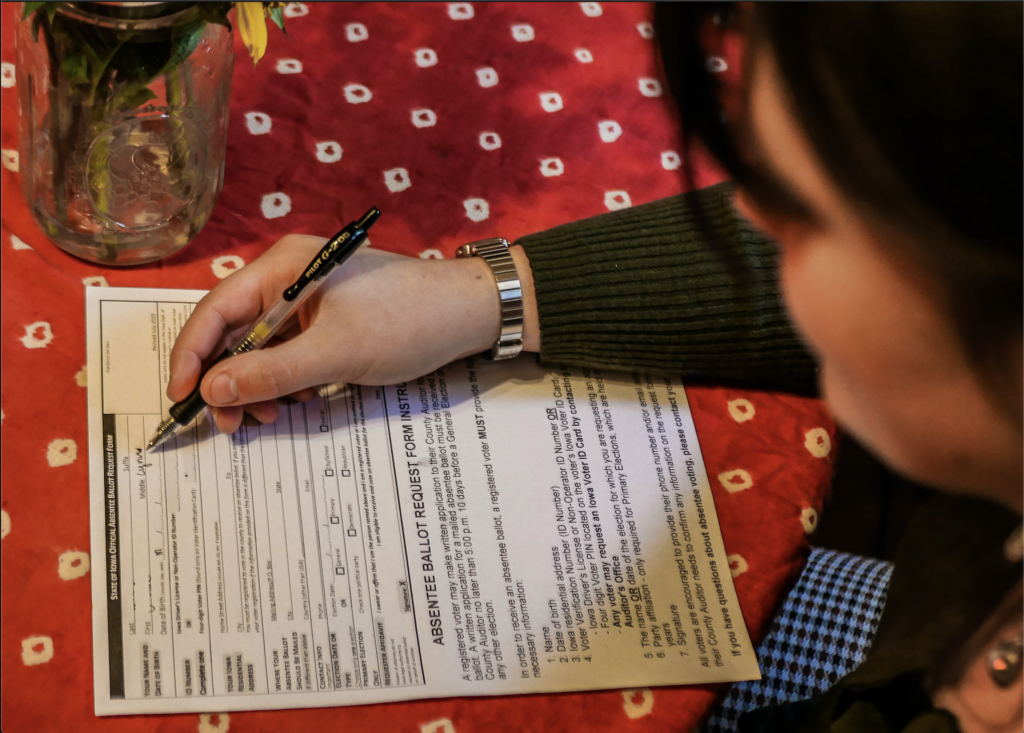 Chloe Wray 21 fills out her absentee ballot request form at home in Grinnell. Photo by Elena Copell