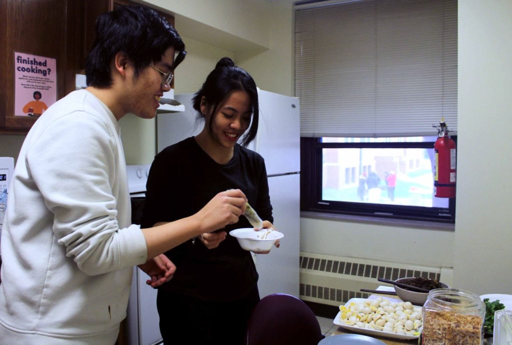Philip Le `22 (left) and Vi Ahn Vu `22 (right) make rice rolls in preparation for Food Bazaar.  They were using one of the dorm kitchens to prepare 50 servings of food. Photo by Ariel Richards