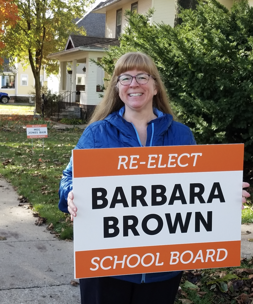 Incumbent candidate Barbara Brown poses with her yard sign. Photo contributed by Barbara Brown. 