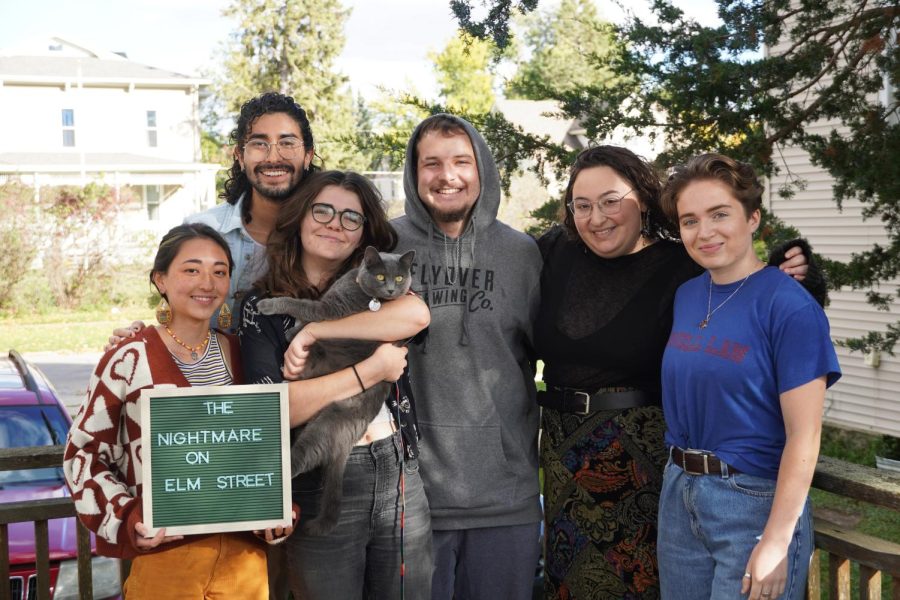 1033 Elm Street poses with the portly cat Mercury. (From left: Kaya Matsuura, Lucien DeJule, Lily Thornton, Will Donaldson, Isabelle Madorsky and Maren Gingerich, all `23.)