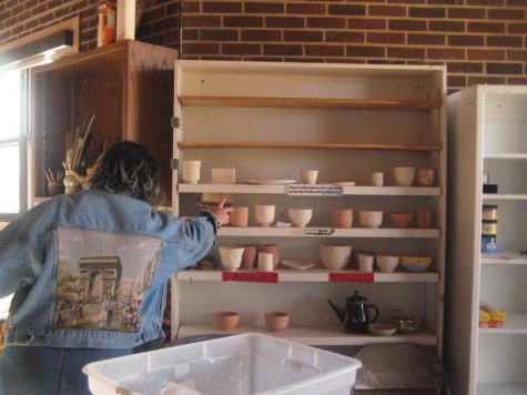 Student Ceramics Studio monitor Zo Zentner `25 reaches for bisque, or
fired, unglazed ceramic pieces, in the studio.