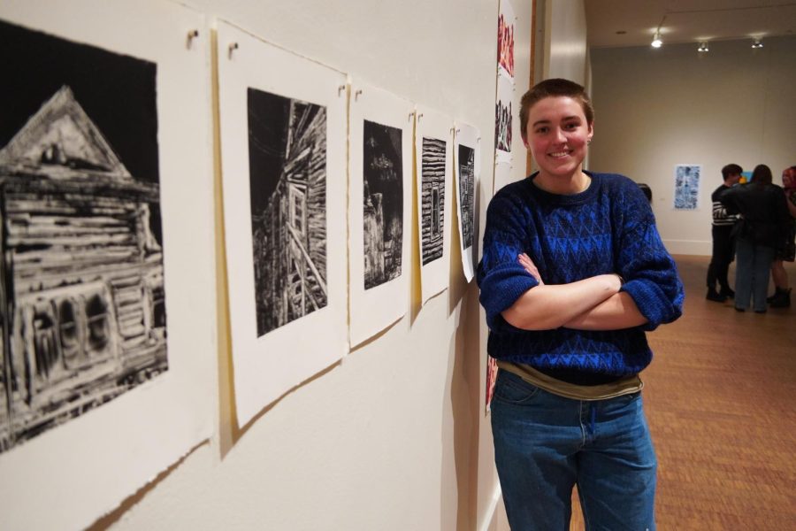 Harper posed next to a wall of prints.