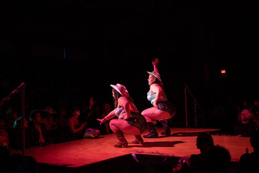 Dayana Phallactic Shock and Bella Louise VanDem Fontayne on stage in cowboy boots and sparkly metallic tops.