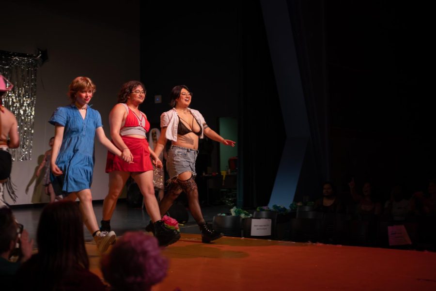 The three performers in TBoy and Co. stride down the runway holding hands.