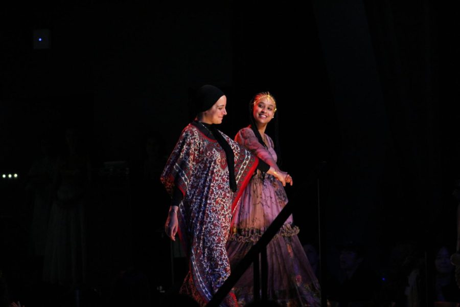 Feven Getachew and Salma Abouhatab walk the runway and smile at one another.