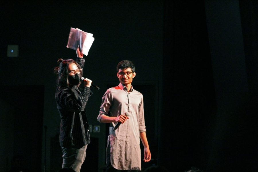 Joel Eom and Sagnik Ghosh hold mics on stage.