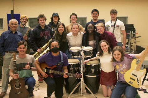 Ensemble members pose as a group around their instruments.