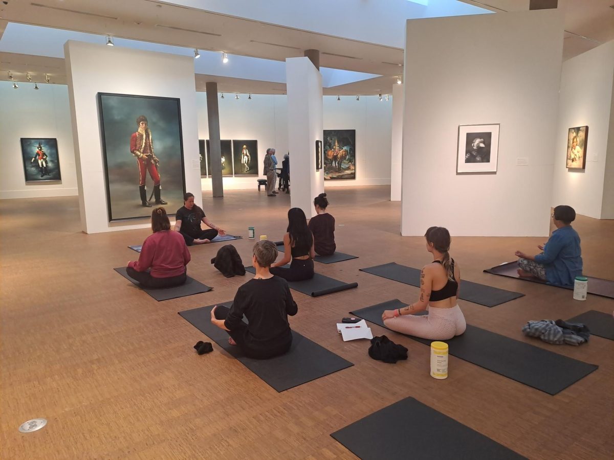 Grinnelllians participate in calming yoga exercises surrounded by art.
