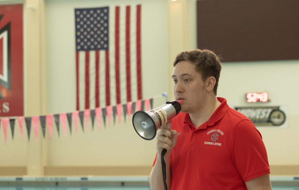 Matt Hedman holding a megaphone at a Grinnell swim and dive practice. He joined the program as head coach this summer. 