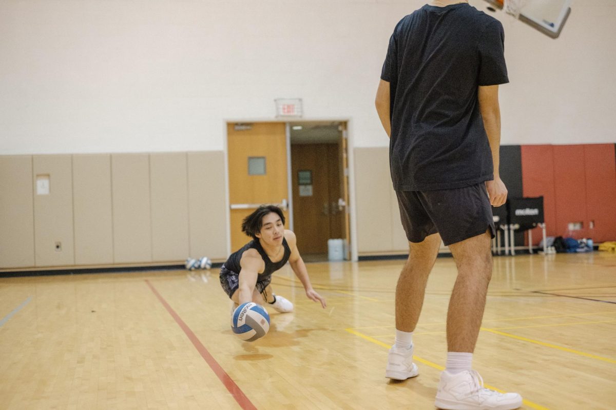 Bryant Nguyen `25 dives for the ball during a volleyball club practice.