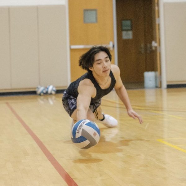 Bryant Nguyen `25 dives for the ball during a volleyball club practice.