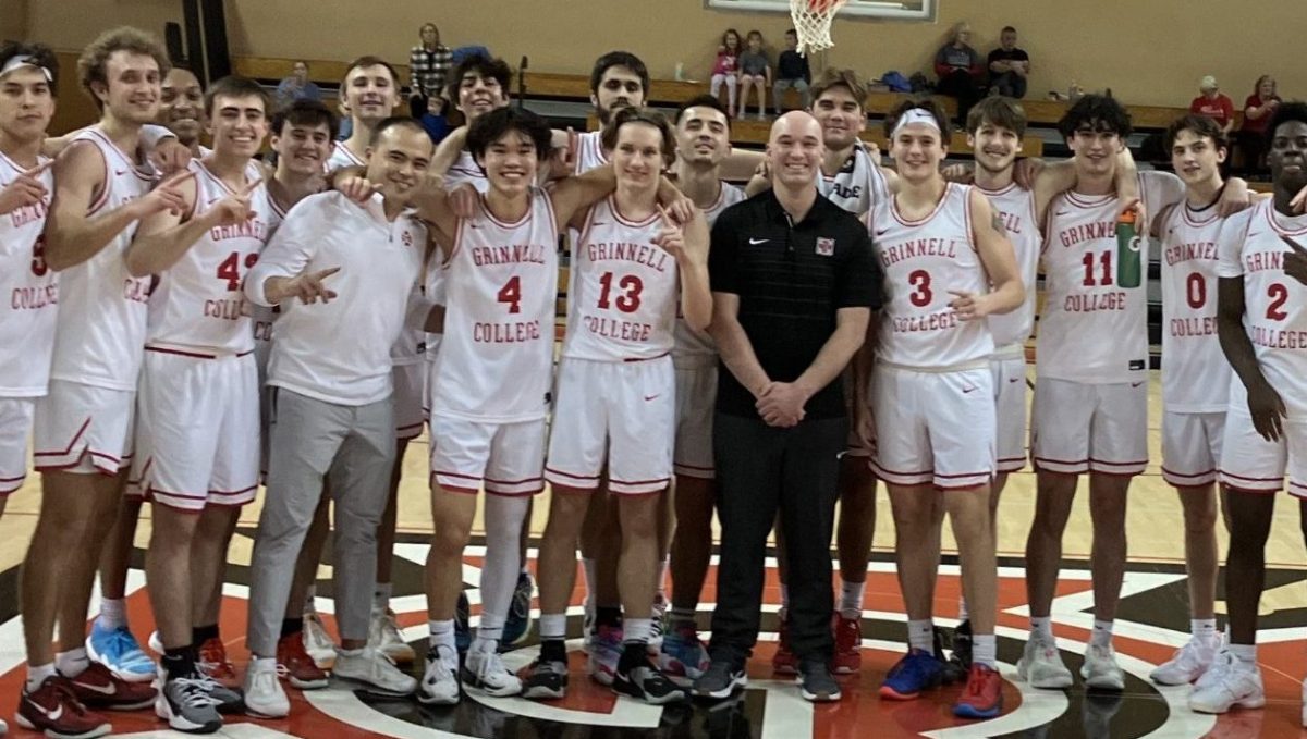 Head Coach David Arsenault Jr. `09 poses with the mens basketball team after his 100th career win at the collegiate level. The Pioneers beat Lake Forest College 148-123 during that game on Nov. 25.