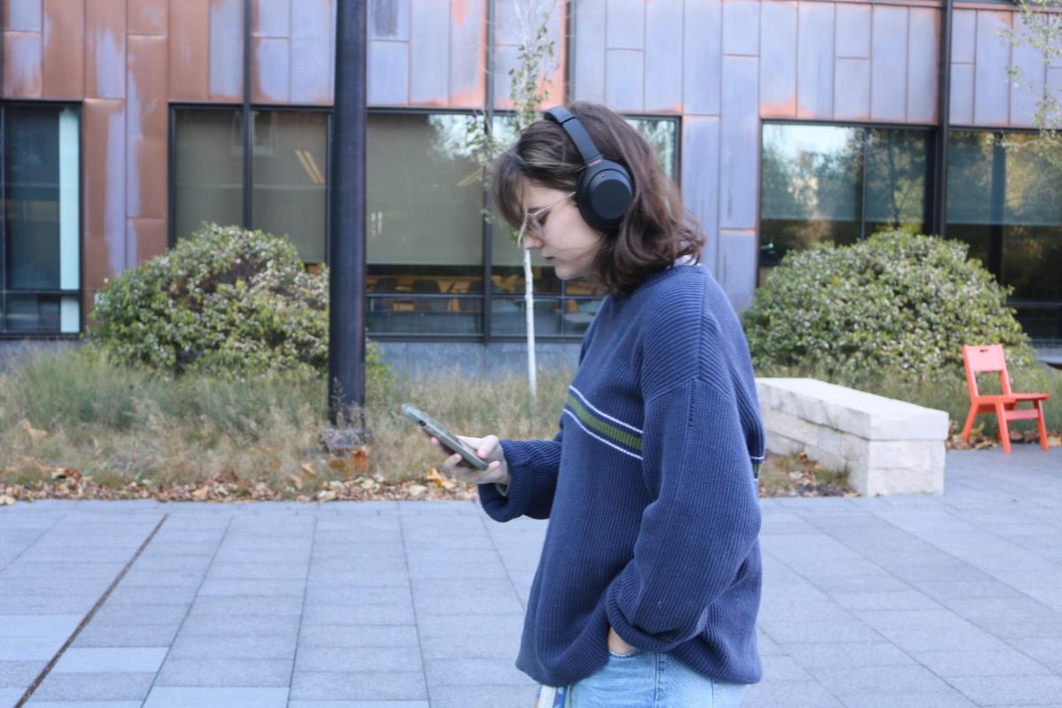 Molly Wilcoxson `26 browses her musical library on a stroll by the Humanities and Social Sciences Center (HSSC).