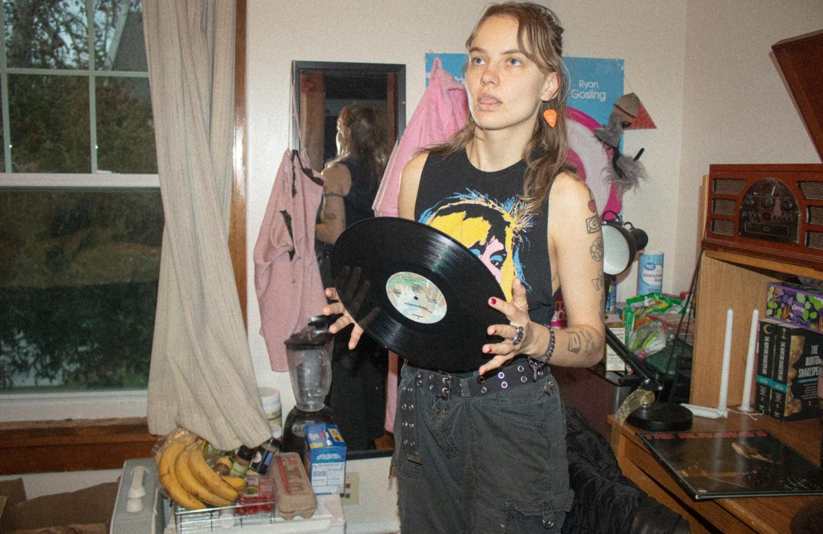 Krista Spies `24 poses in front of her Barbie poster with a vinyl copy of The Runaways self-titled record.