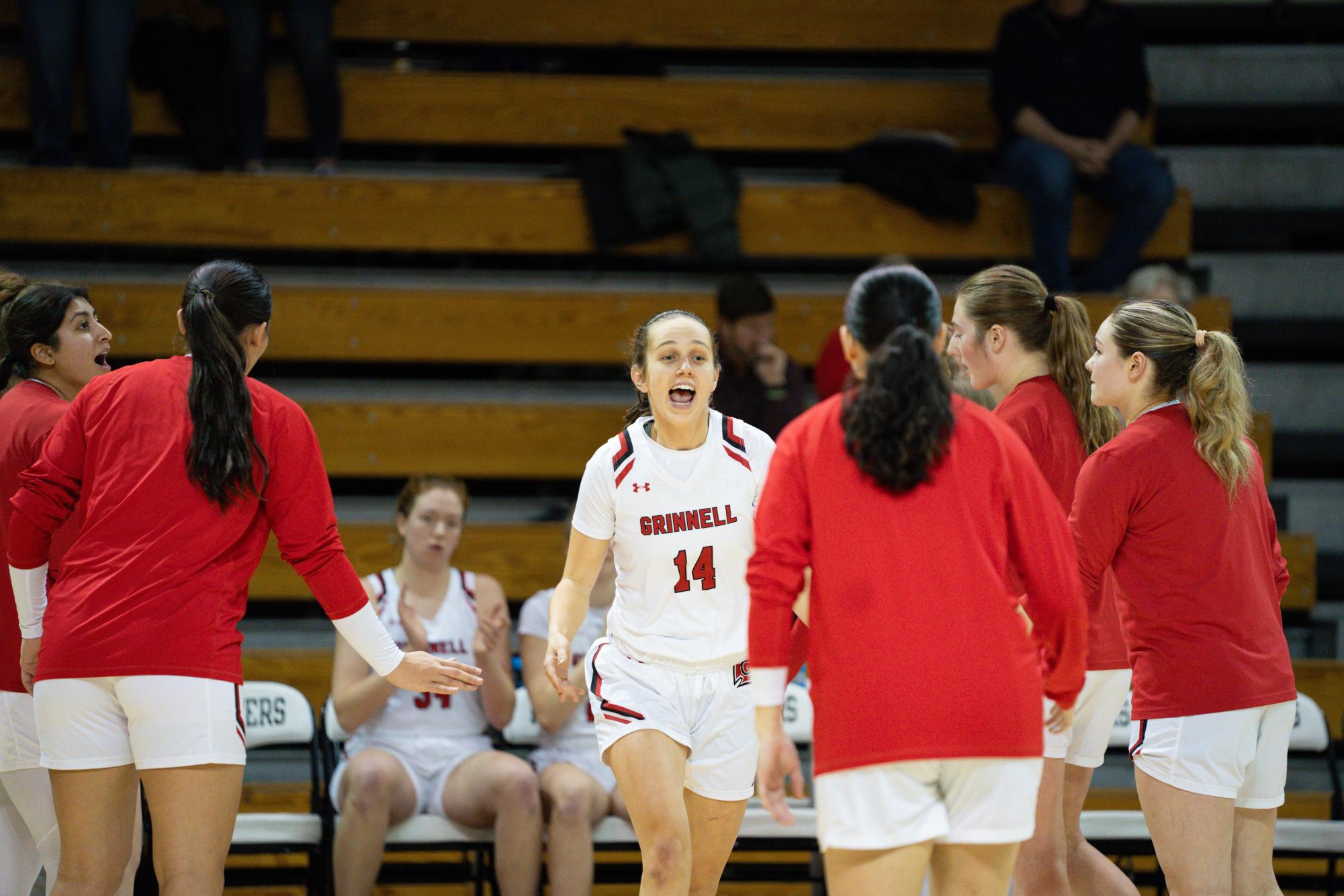 Erin Lillis `24 celebrates with her teammates during the Feb. 7 game against Illinois College. The Pioneers won 78-63 to secure Head Women’s Basketball Coach Dana Harrold’s 100th career victory.