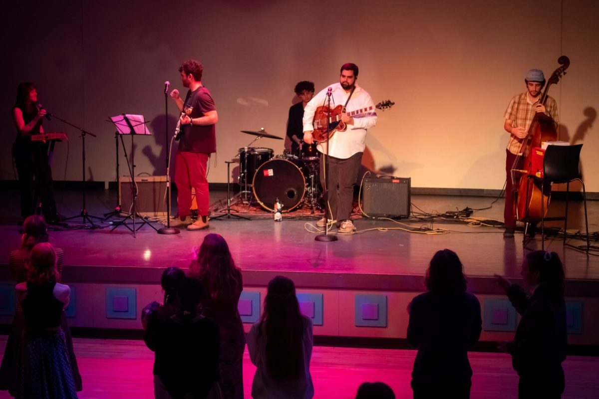Grinnell College student band plays their debut performance at Masquerade Harris. On the stage from left: Maddie Church `27, Theo Richter `24, Renzo Iurino `27, Grant Anguiano and Noah Mendola `26.