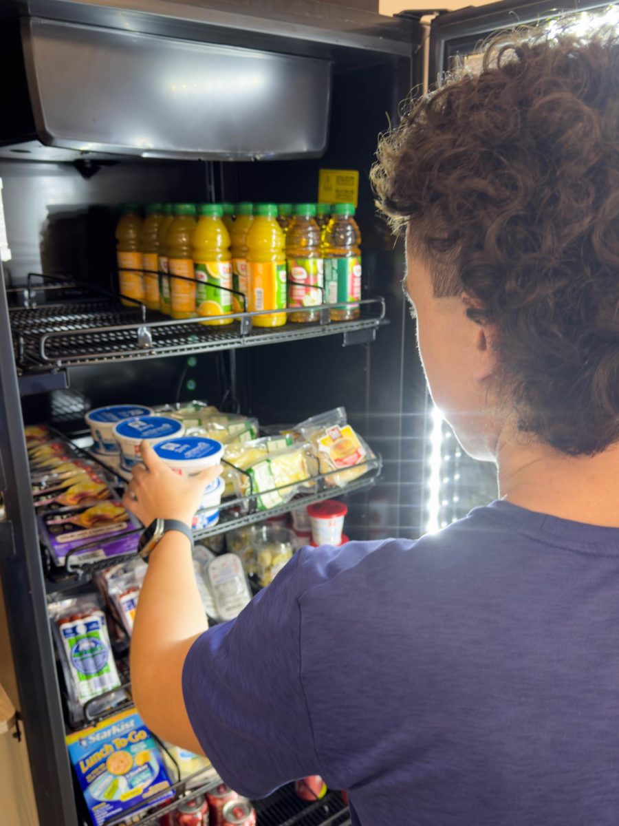 A student purchases a snack from the vending machine in the HSSC. 