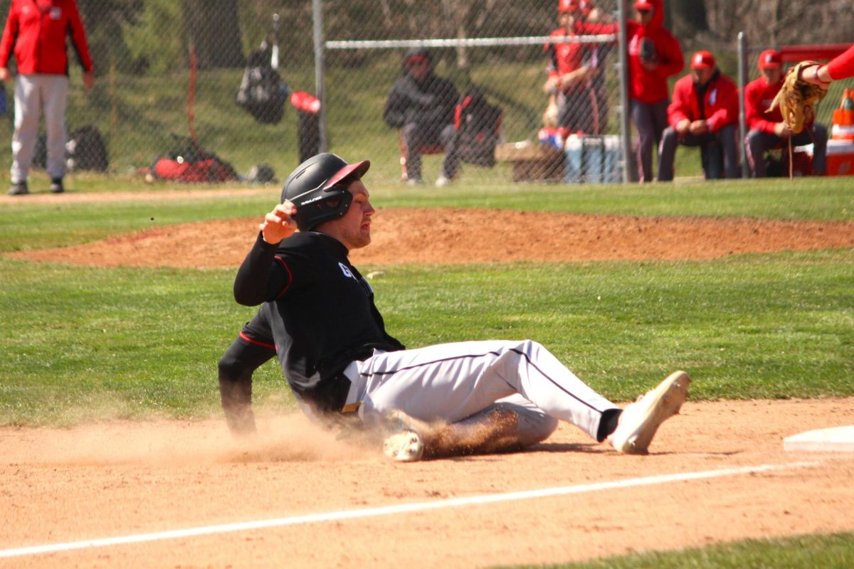 Michael Flaherty 24 slides to safety against Monmouth College on March 30.