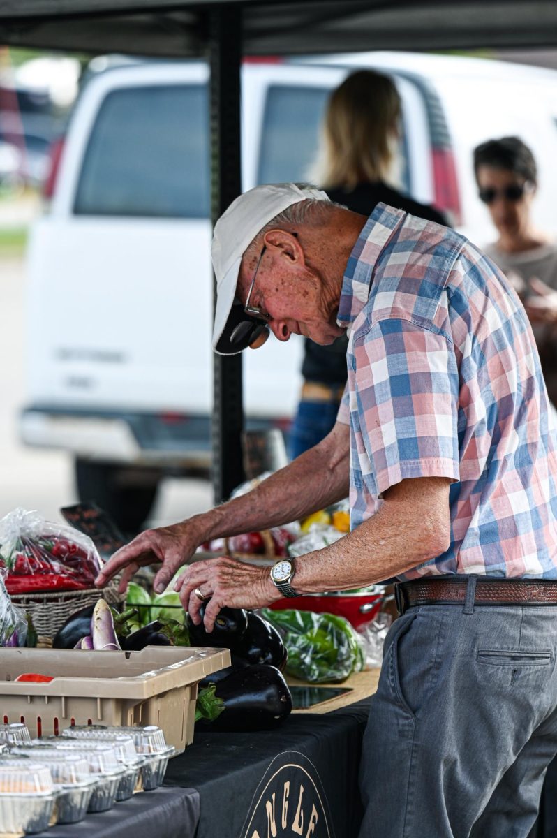 A community member browses offerings at the Grinnell farmers market on Broad Street. 