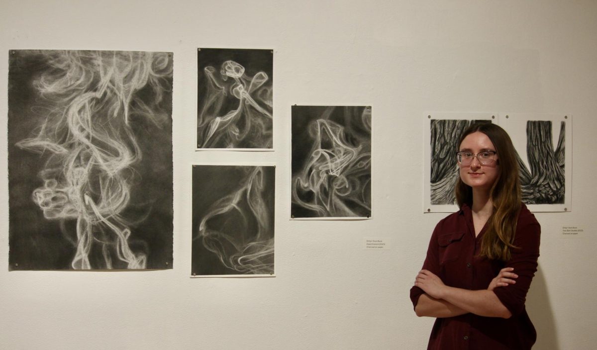 Emlyn Yoon-Buck ’25 stands beside ‘Impermanent’ — her charcoal artwork at the Edith Renfrow Smith `37 Gallery in the Joe Rosenfield `25 Center.