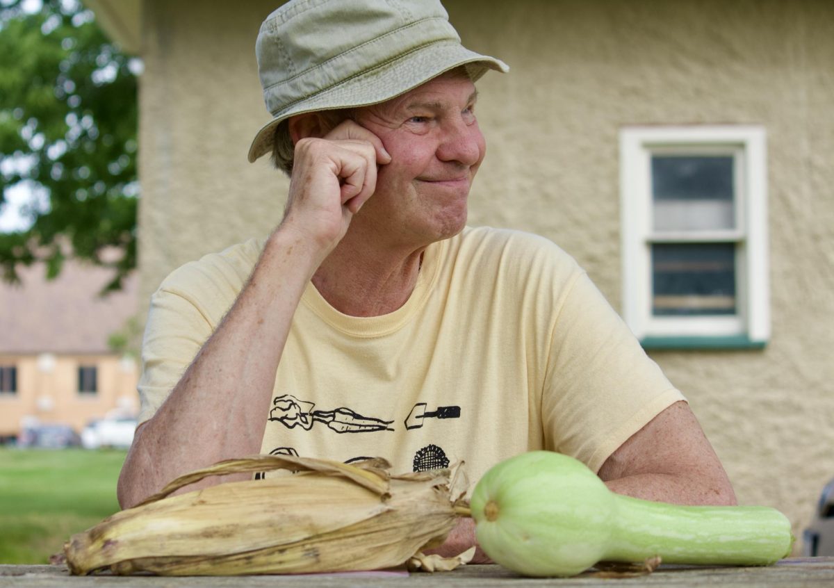 Jon Andelson, professor of anthropology and supervisor of the Grinnell College Garden, sits with produce from the Grinnell College garden.