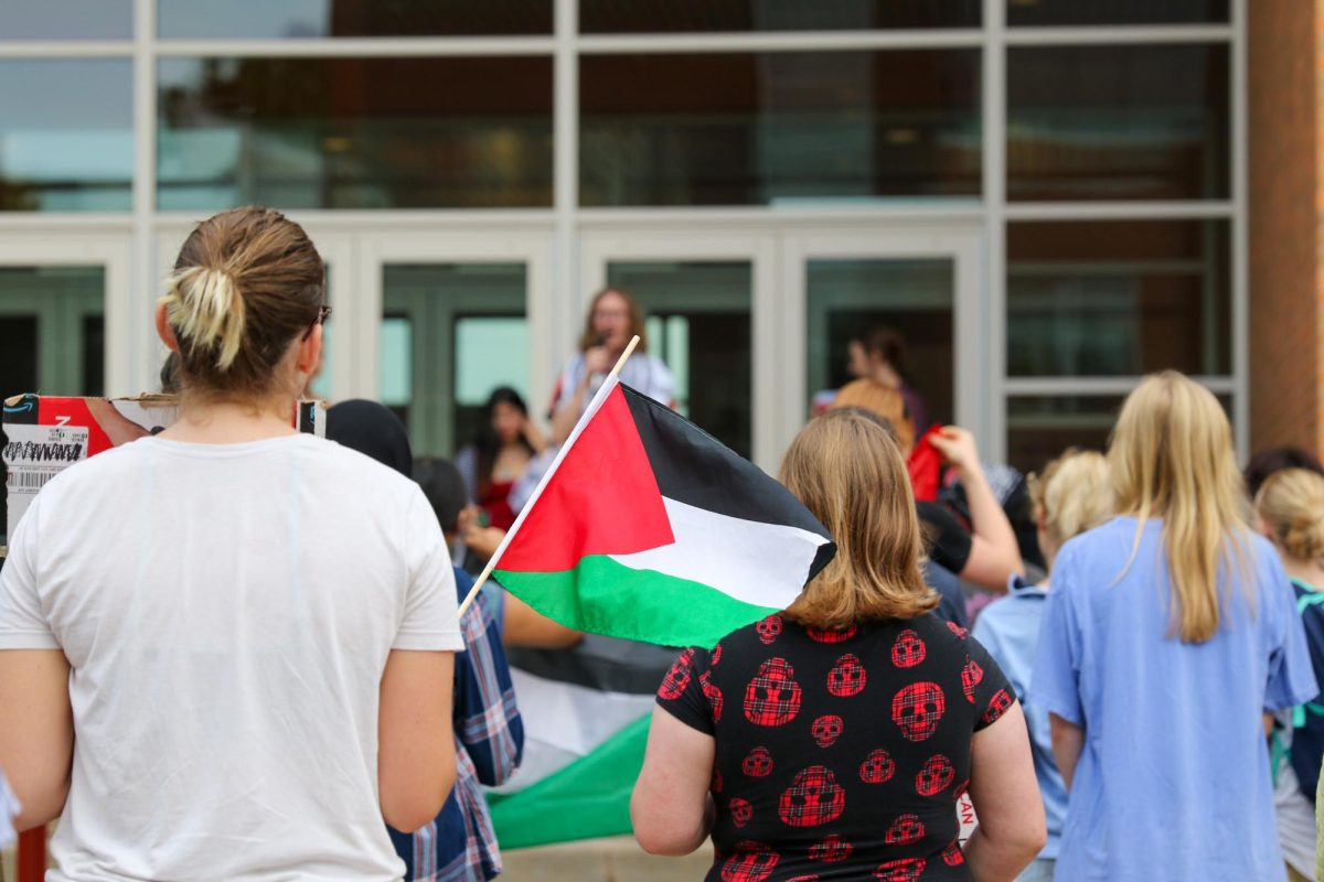 A student waves a Palestinian flag outside the Joe Rosenfield Center `25 during a Grinnell Students for Justice in Palestine (SJP) rally held Sept. 19.