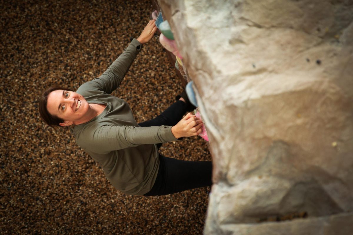 Amanda Preperato, director of Grinnell Outdoor Recreation Program, climbs the rock wall in the Bear.