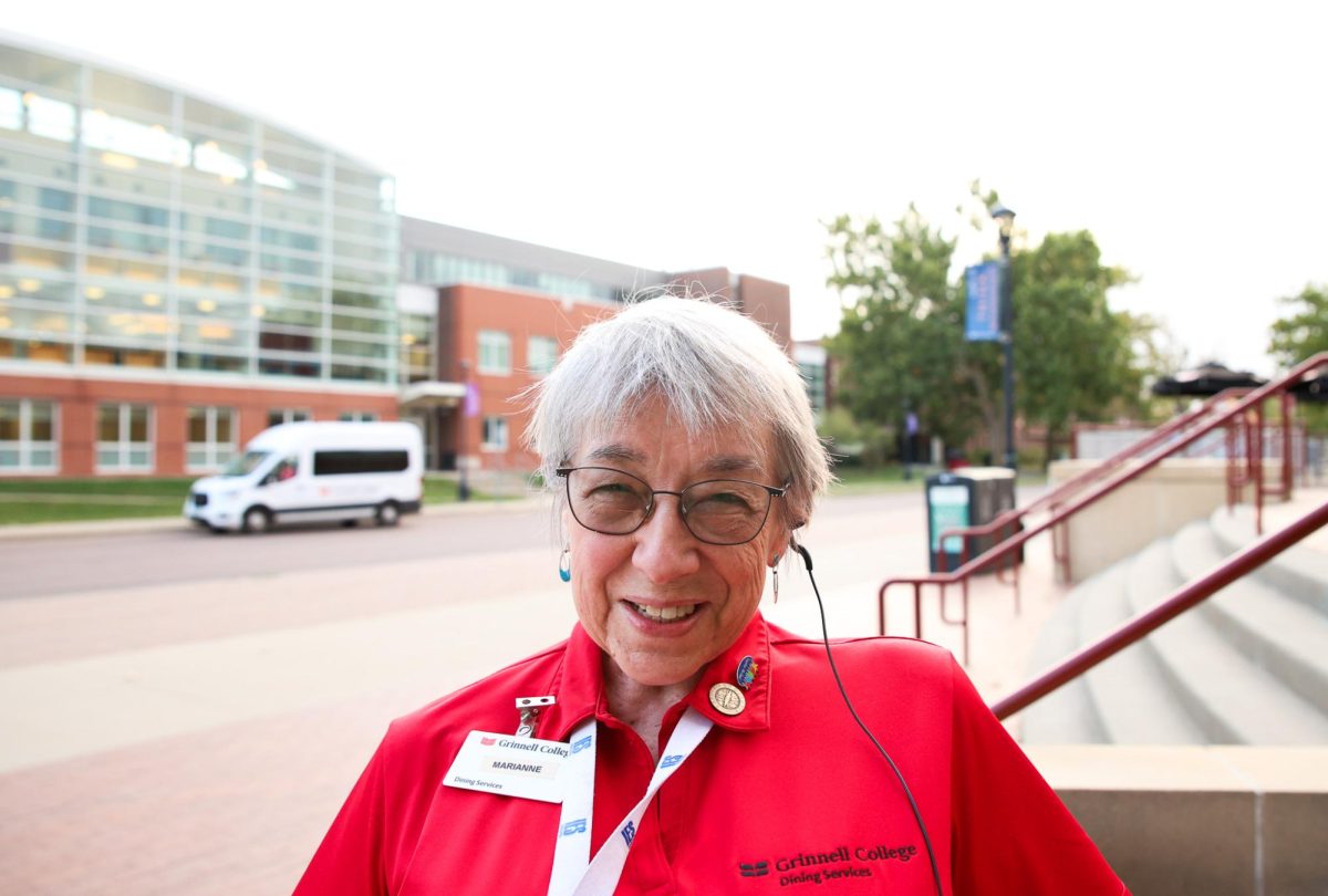 Marianne Ronan, a "cheery checker" at the Marketplace Dining Hall, poses for a portrait outside the Joe Rosenfield Center (JRC), where she worries over students who cross the street on her way to work.