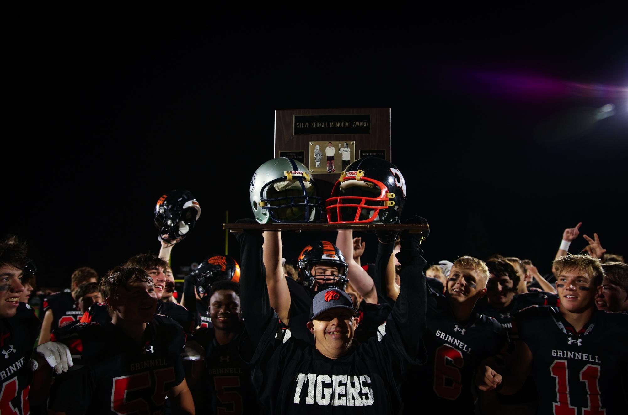 Grinnell High School football players raise the trophy after a commanding 45-7 win over South Tama County on Friday, Oct. 4, 2024.