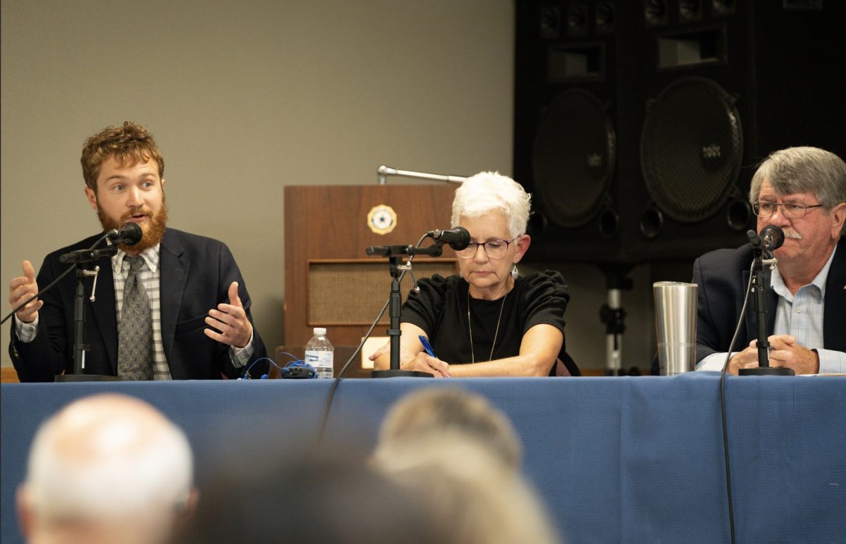 From left: Tommy Hexter `21, moderator Joanna Hofer, and Dean Fisher, seated at debate table on Fri. Oct. 4, 2024. 