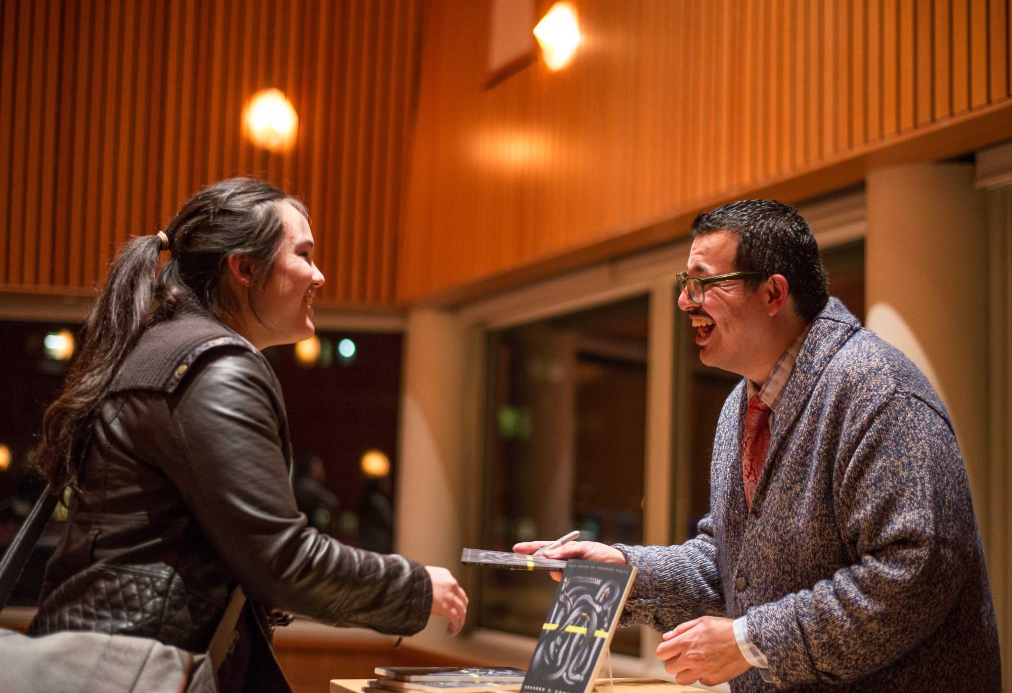 Corral signs books after his reading at hist 2014 Writers @ Grinnell Book Talk.