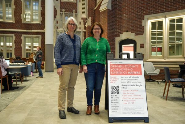 From left: Joyce Stern, dean for student success and academic advising, and Andrea Tracy, associate dean of student academic life, pose in front of a sign advertising the academic advising survey.