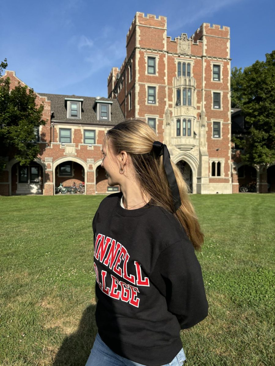 Laura Kövécs poses in front of Gates Tower, clad in her burning red Grinnell merch.