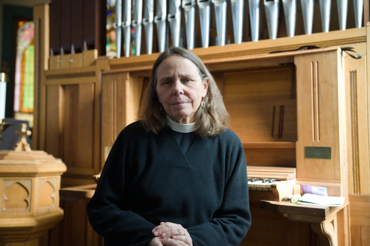 Rev. Wendy Abrahamson sits by the organ in St. Paul's Episcopal Church in Grinnell, Iowa.