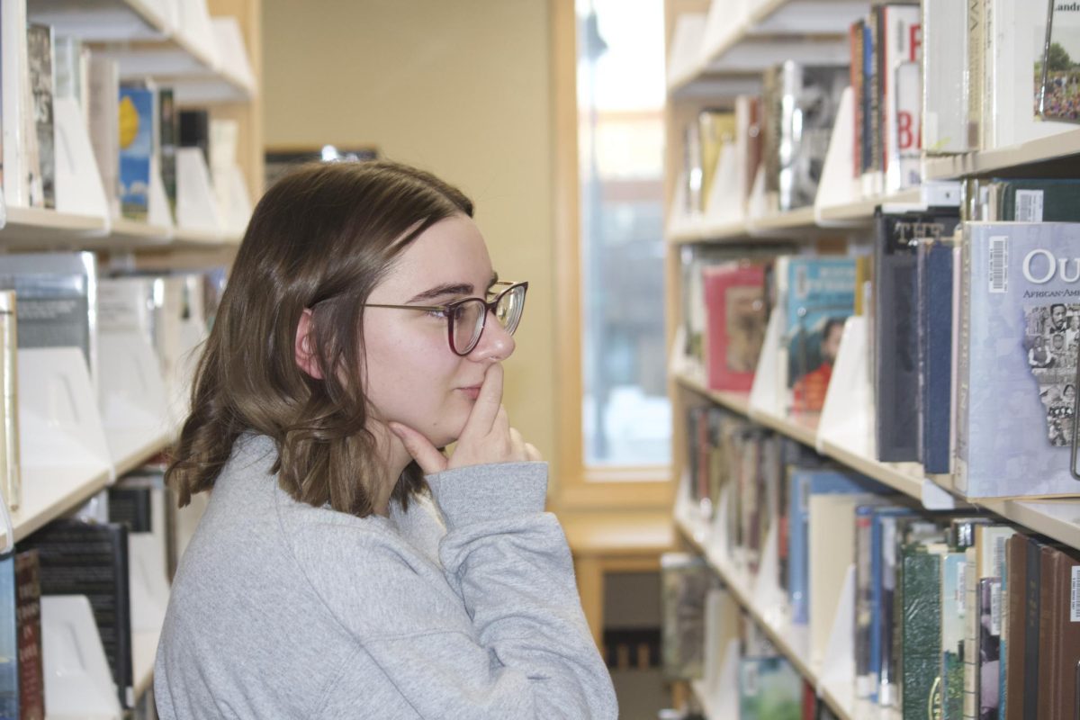 Veronica Ruse `19 currently Library Assistant at Drake Community Library in Grinnell poses at Drake. 
