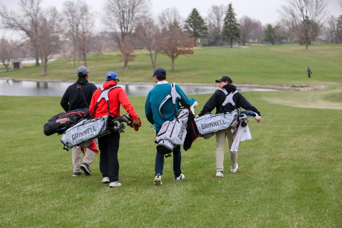 Grinnell men's golf walking to tee-off at the next hole at the Grinnell College Golf Course during practice on April 11, 2025.