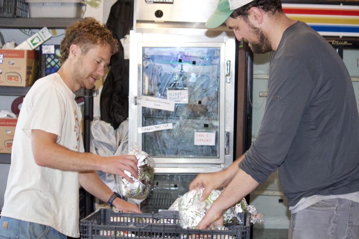 Tommy Hexter `21 and Jordan Scheibel `10 unloading cabbages inside of Grinnell Farm to Table. 