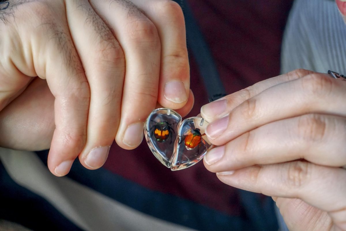 From left: Jayson Kunkel `26 and Maya Albanese `26 put together their heart necklace that they both have a piece of.