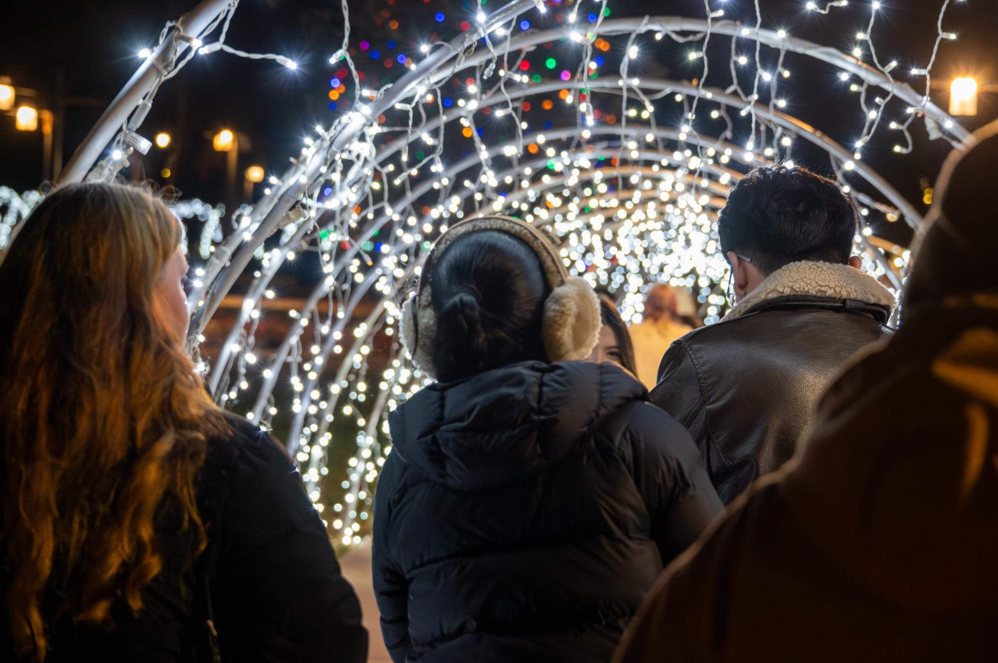 A group of Grinnell College students walks through the Christmas lights in Grinnell’s town square on Friday, Nov. 21, 2025 during Jingle Bell Holiday. 