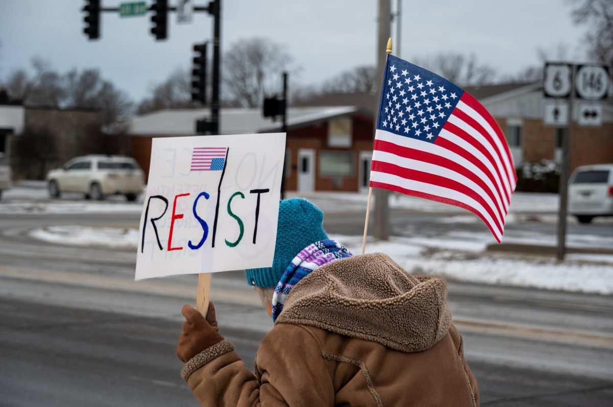 A protester holds a sign reading "RESIST" in Grinnell, Iowa on Jan. 20, 2026.