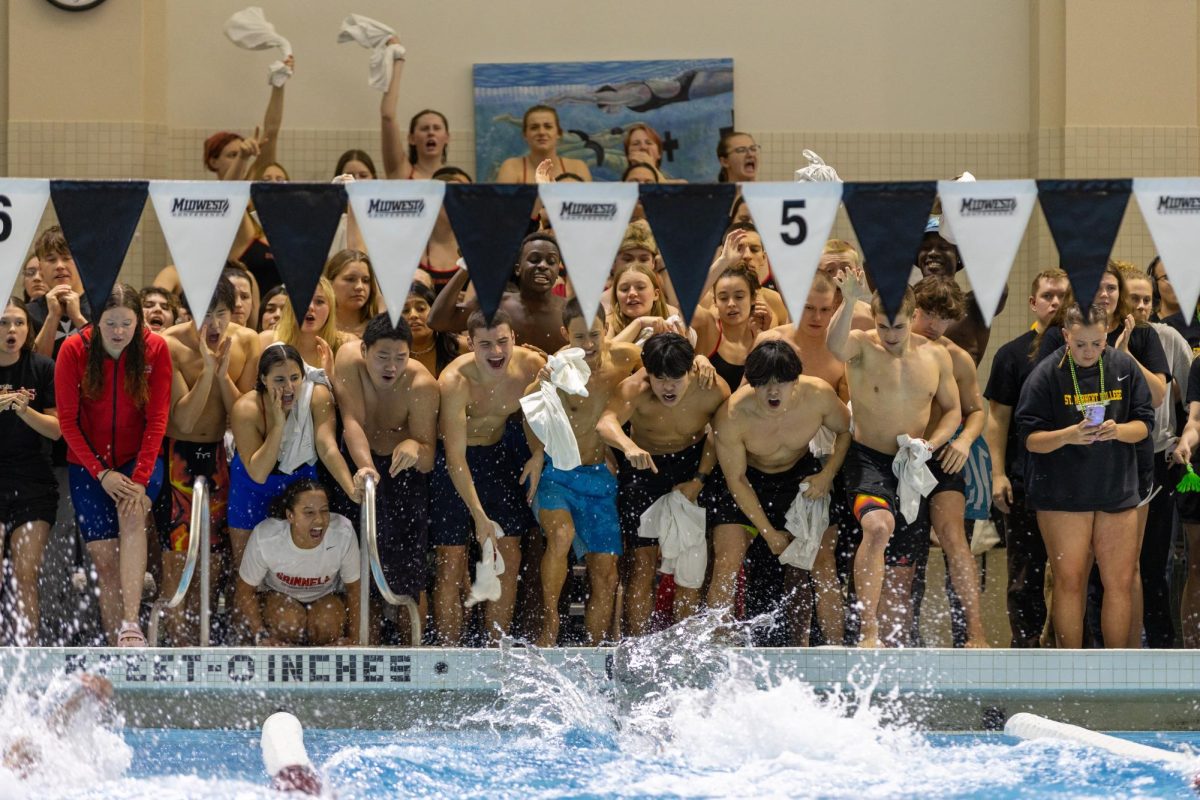 The Grinnell swim and dive team cheer on the men’s 400-meter free relay team at the 2026 Midwest Conference Swim Meet at the Russell K. Osgood Natatorium on Sunday, Feb. 22.